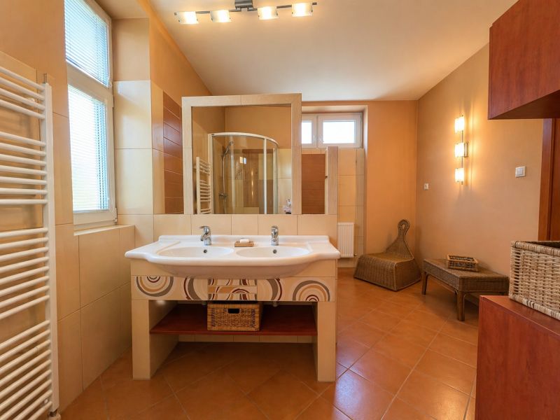 A bathroom in a 4-room apartment with a double sink and a shower.