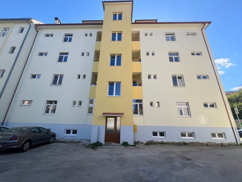 A portable building in Banská Bystrica with a parking lot in front of the entrance.