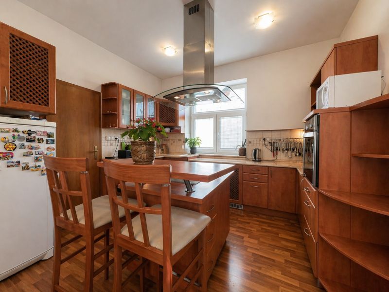 A kitchen in a 4-room apartment with a wood decor, centrally located island.