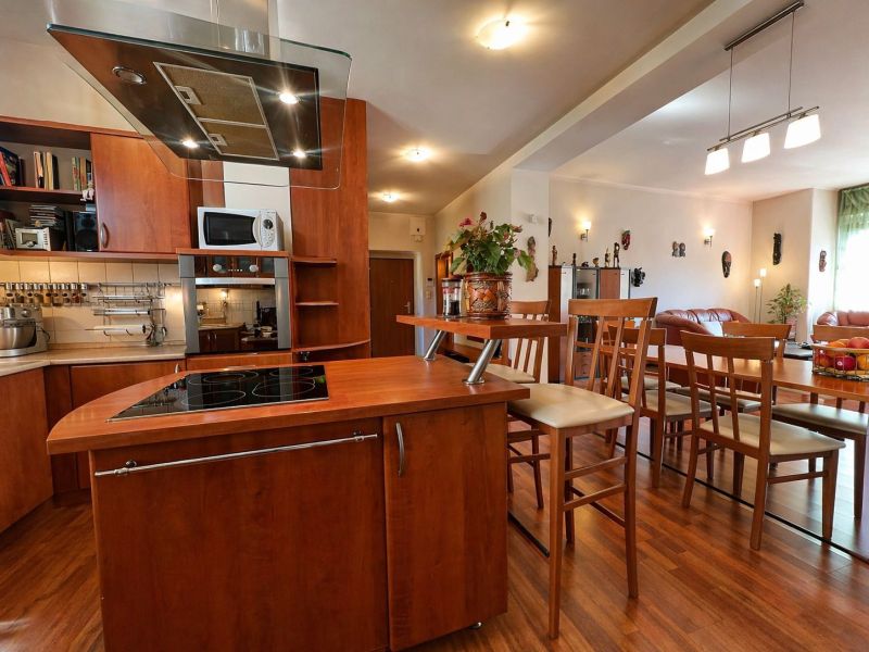 Kitchen and dining room in a 4-room apartment with wood decor and modern furnishings.