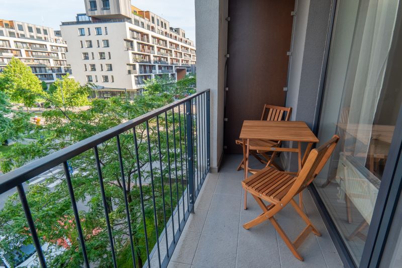 The balcony of a 1-room apartment on Zuzany Chalupovej Street, Bratislava - Petržalka with wooden furniture.
