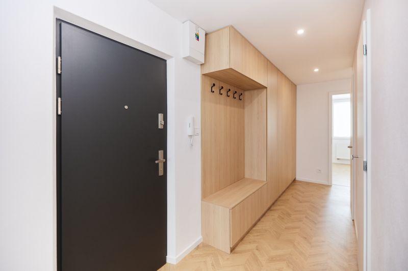 Entrance hall in a 4-room apartment with wood-patterned flooring and storage space.