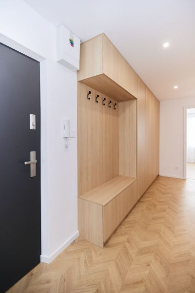 A hallway with built-in furniture and a floor with a wooden decor in a 4-room apartment.