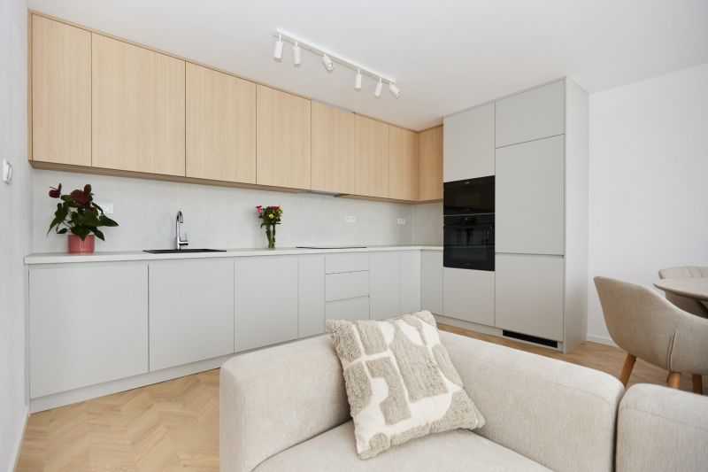A kitchen in a 4-room apartment with wooden decor, light cabinets, and a comfortable couch.