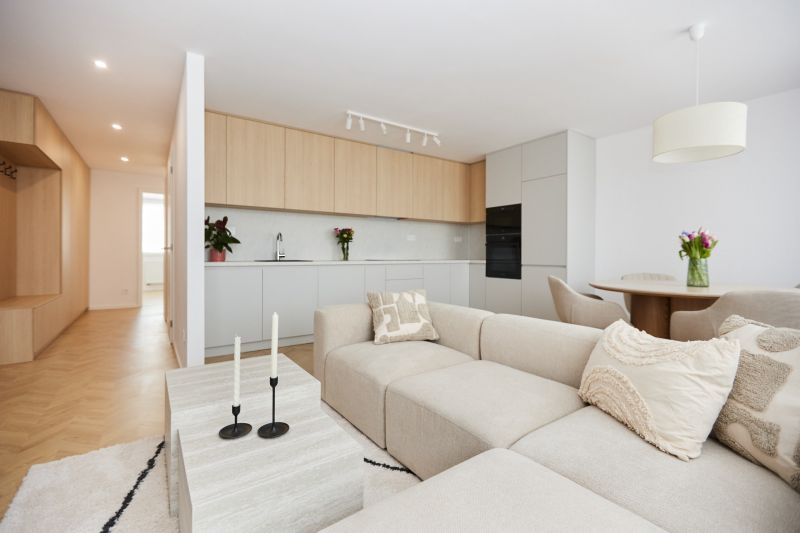 A spacious living room in a 4-room apartment with a kitchenette and a floor with a wooden decor.