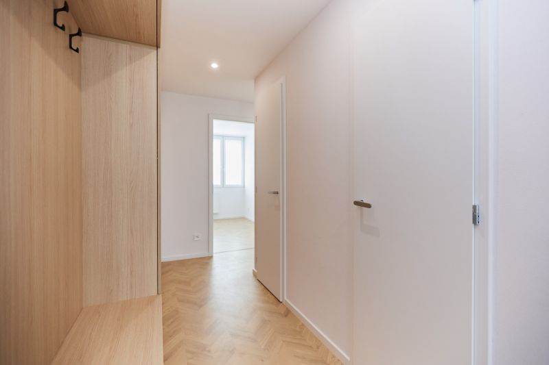 A hallway in a 4-room apartment with a wooden decor floor and a built-in wardrobe.