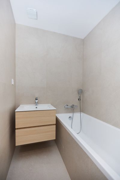 A bathroom in a 4-room apartment with a bathtub and a cabinet with a sink.