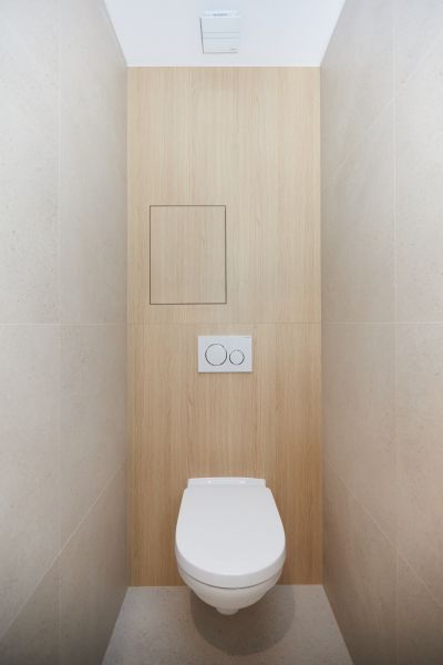 A toilet with a wooden decor floor in a 4-room apartment.