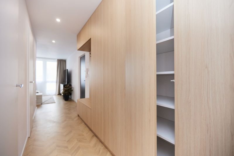 A hallway with built-in wardrobes in a 4-room apartment with a floor featuring a wooden decor.
