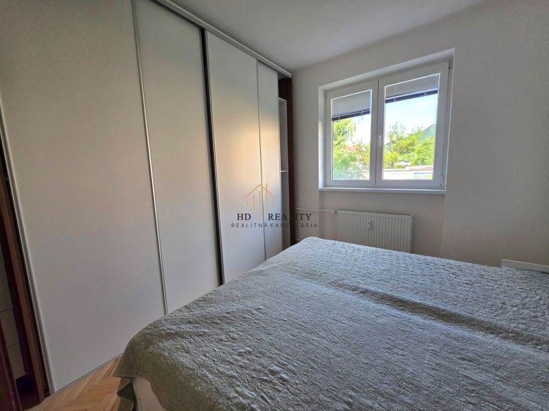 Bedroom with a built-in wardrobe and a window in a 2-room apartment.