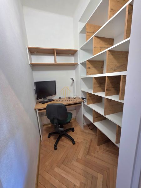 A workspace with a wooden decor floor and shelves in a 2-room apartment.