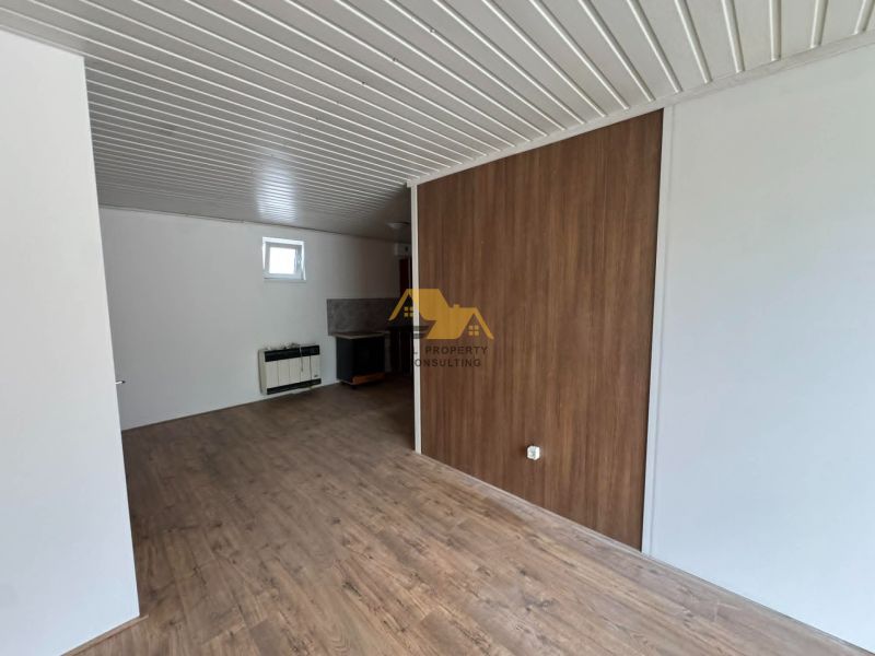 2-room apartment with wood-patterned flooring and white walls.