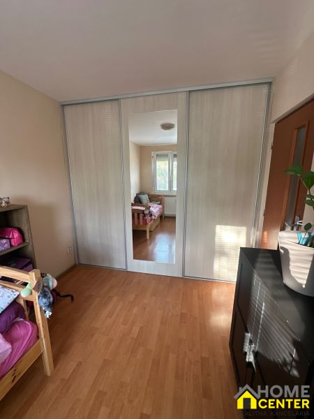 Interior of a 3-room apartment with a wooden decor floor and a built-in wardrobe.