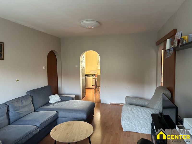 Living room of a 3-room apartment with a comfortable sofa and a wooden decor floor.