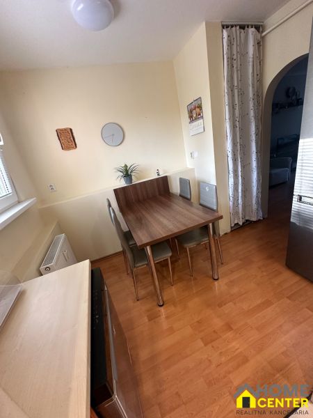 Dining area with a table and chairs in a 3-room apartment with a wooden decor floor.