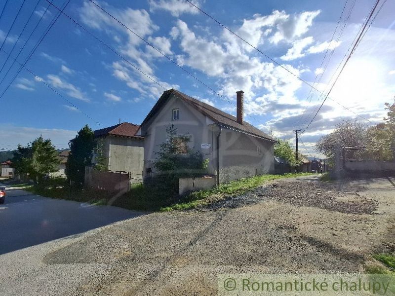 A family house in Šumiac with rural charm, surrounded by greenery and a pale blue sky.