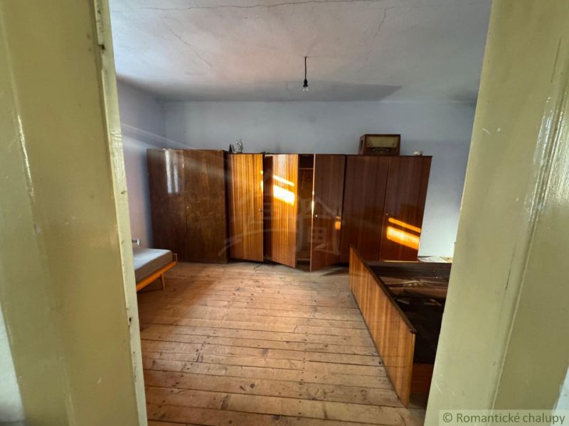 A room in a family house with wooden furniture and a bed on the floor with wooden decor.