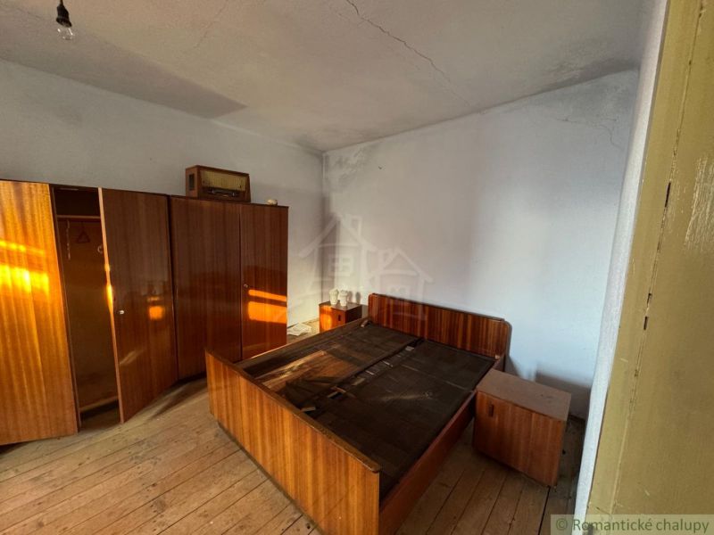 A bedroom with retro furniture and a wooden decor floor in a family house.