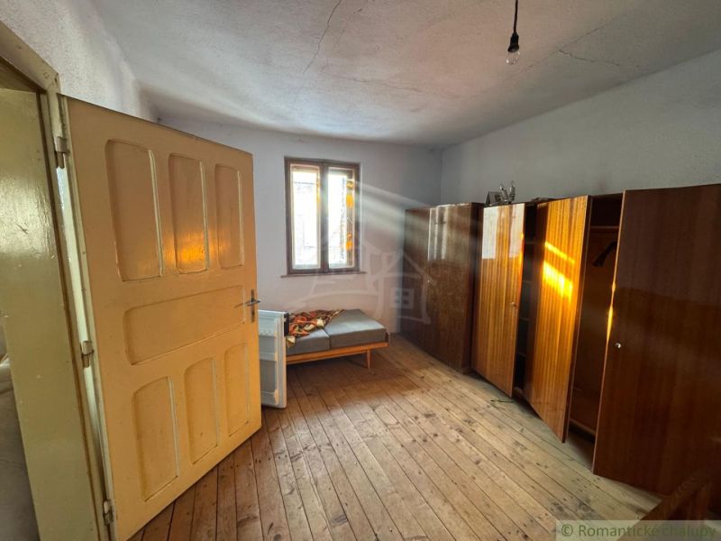 A room in a family house with a floor featuring a wooden decor and simple furnishings.