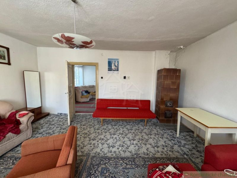 Living room in a family house with a sofa set and a tiled stove.