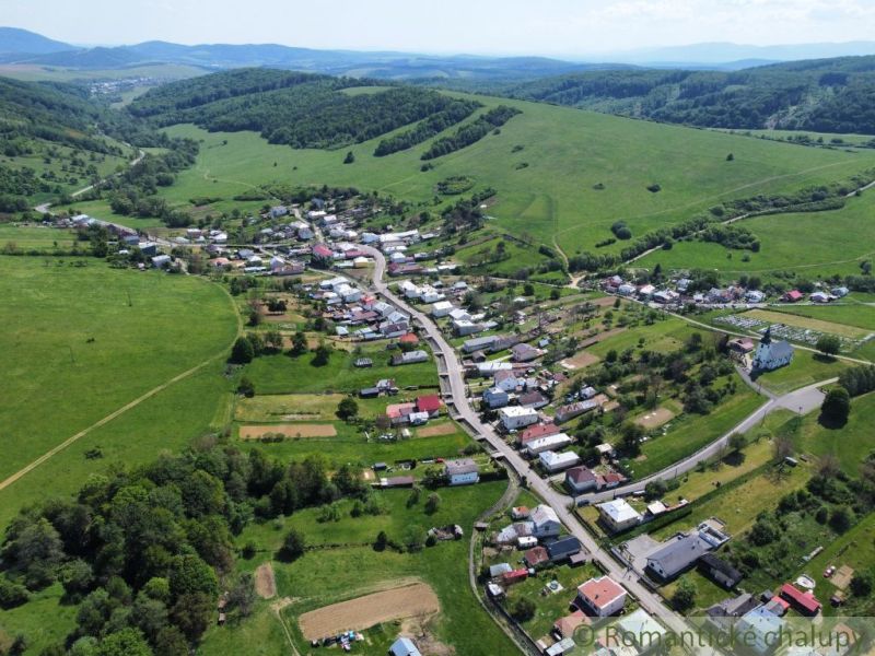 An aerial view of the village of Karná surrounded by hills and residential land.