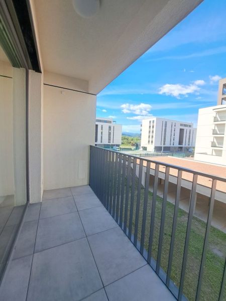 A balcony in a 2-room apartment in Poprad with a view of modern buildings and greenery.