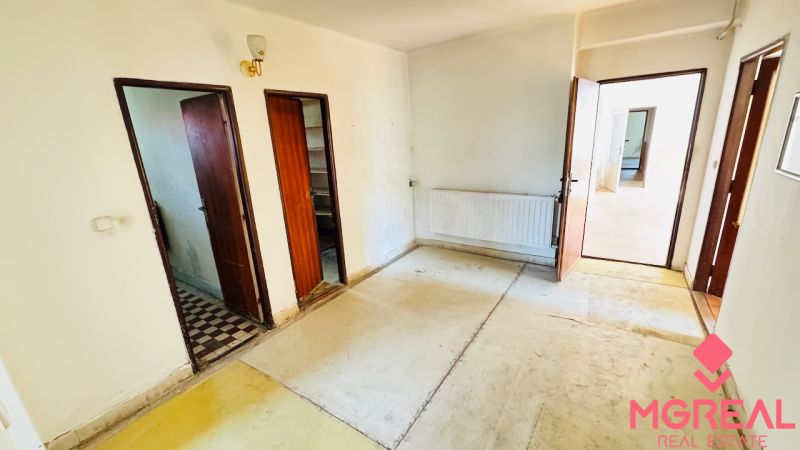 Interior with old flooring, wooden doors, and a radiator in a family house.