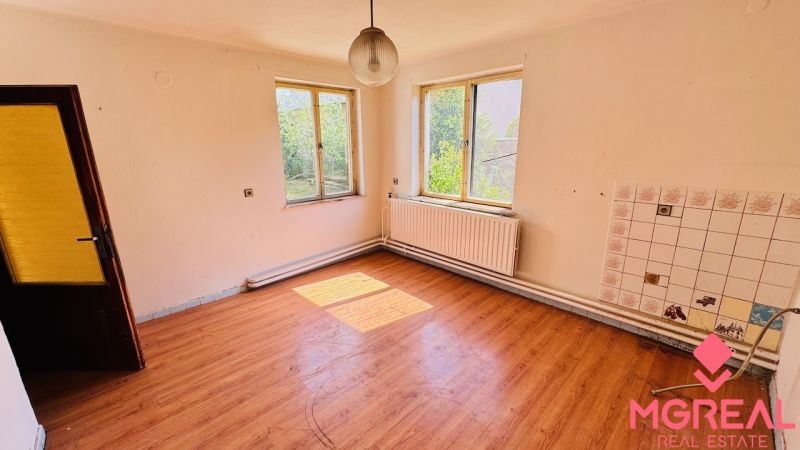 A spacious room with a wood-patterned floor in a family house.