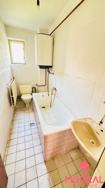 A bathroom in a family house with a bathtub, sink, and toilet.