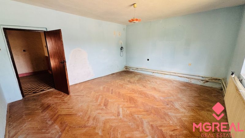 A family house with light blue walls and a wooden-patterned floor.