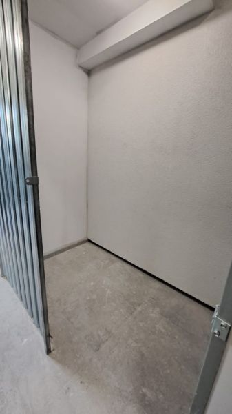 Small storage spaces with metal doors and concrete flooring in a two-room apartment.