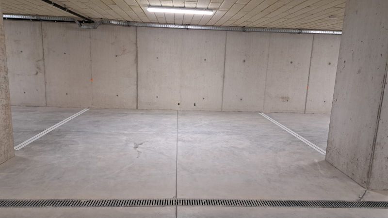 Underground garage with concrete floor and lighting.