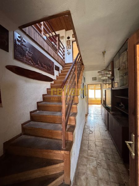 Staircase and hallway with wooden decorations in a family house.