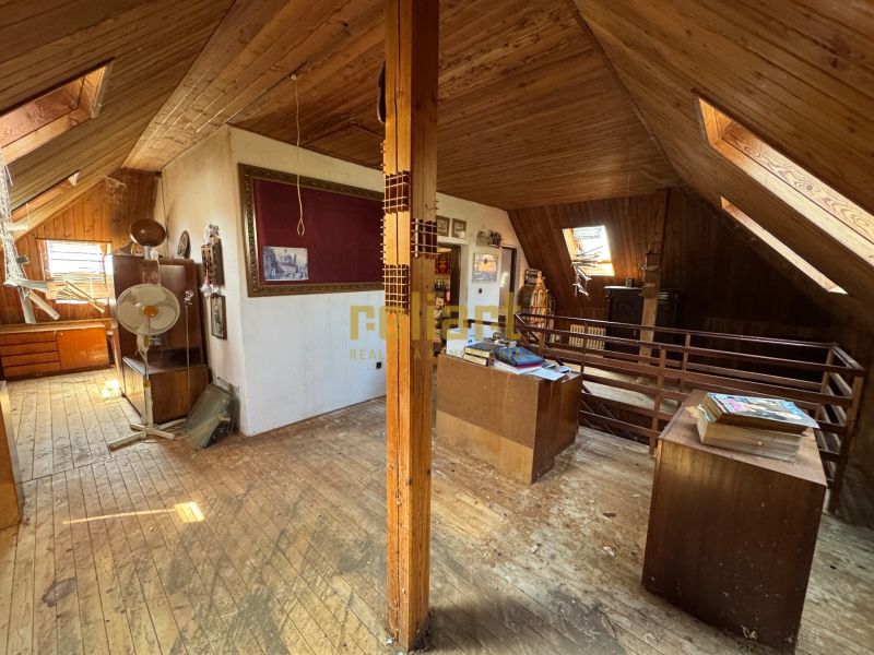 Attic room in a family house with wooden decor, antique furniture, and accessories.