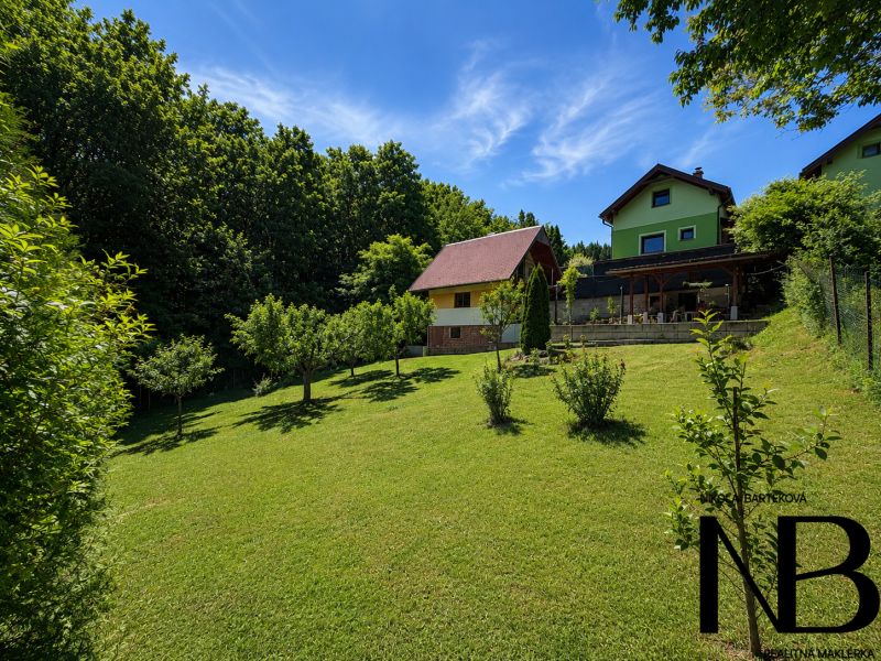 A cottage on Klučina in Považská Bystrica with a well-maintained garden, trees, and green grass.