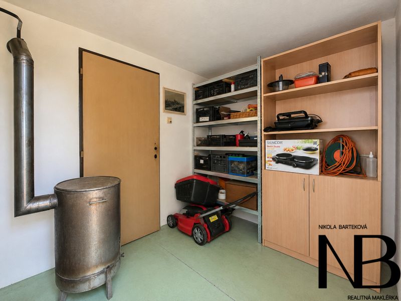 Storage space in the cottage with a stove, shelves, and tools.