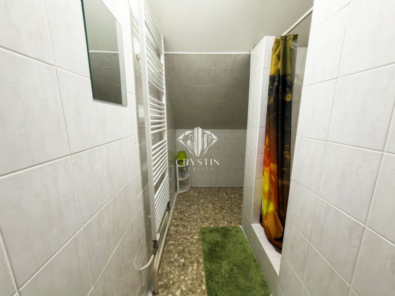 A bathroom in a family house with tiles and a shower.