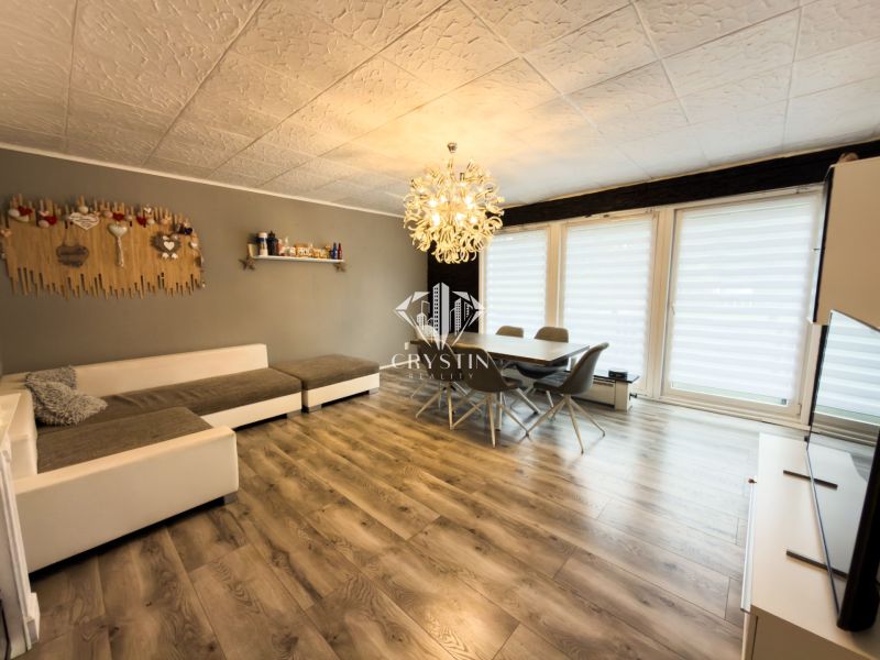 Living room in a family house with a wooden decor floor and large sofa seating.
