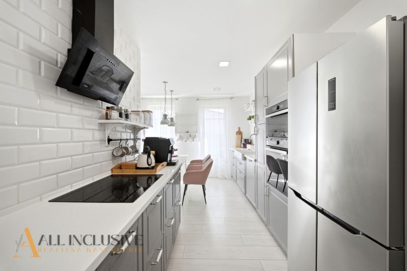 A stylish kitchen in a family house with modern appliances and white paneling.