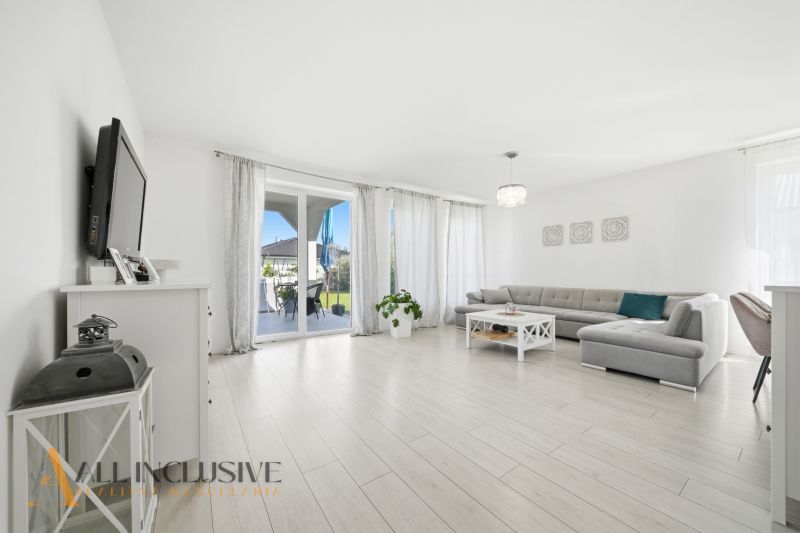 Living room in a family house with a wooden decor floor and a large sofa set.