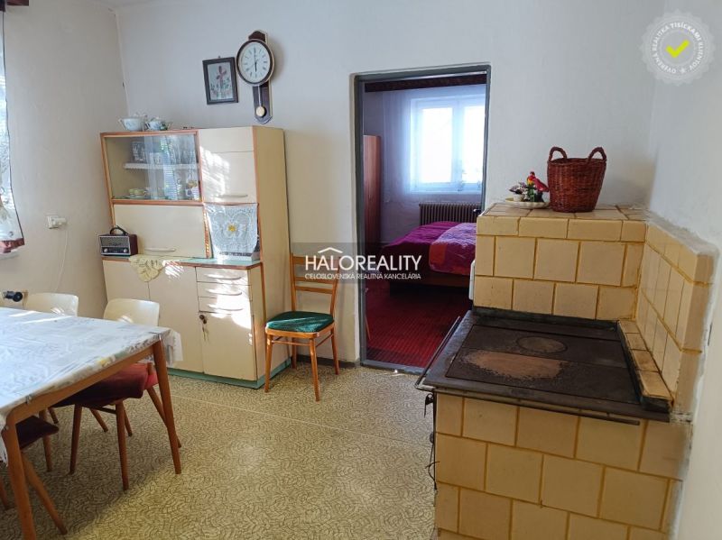 Kitchen in a family house with a stove, dining table, and display cabinet.
