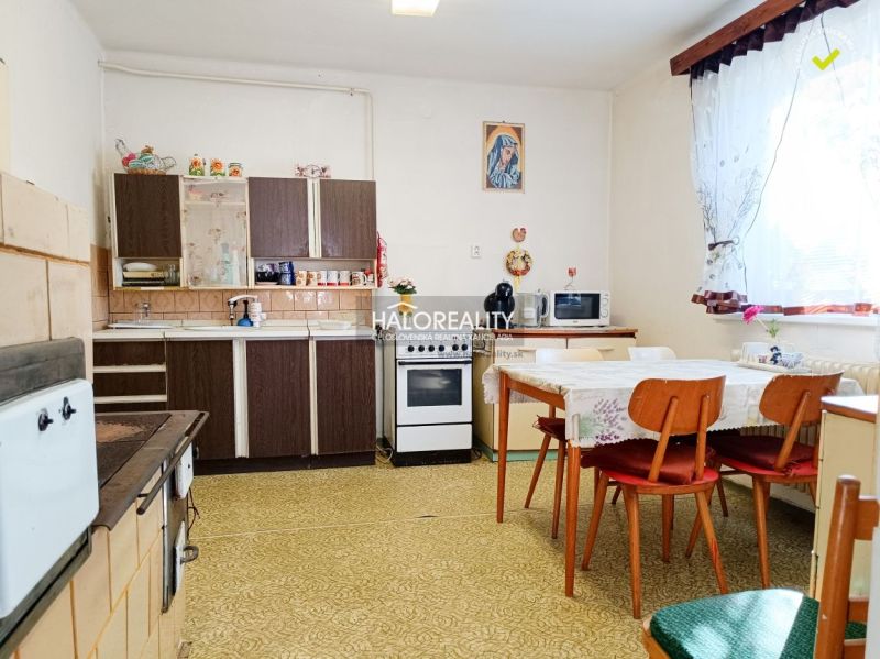 A kitchen in a family house with older furniture, a table, and chairs.