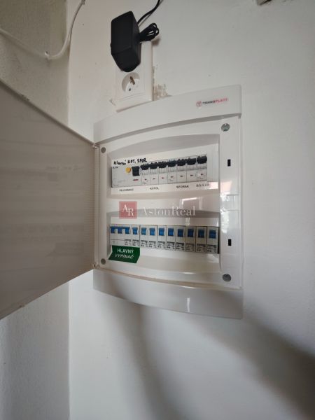 An electrical distribution box in a 2-room apartment with open doors and a socket.