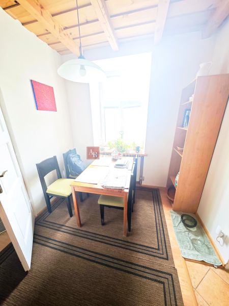 Dining area with a table, chairs, and shelves in a 2-room apartment.