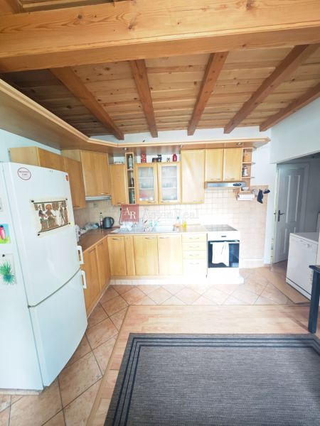 A kitchen with a wooden decor floor and ceiling beams in a 2-room apartment.