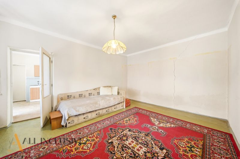 A room in a family house with a bed, light, and an oriental carpet.