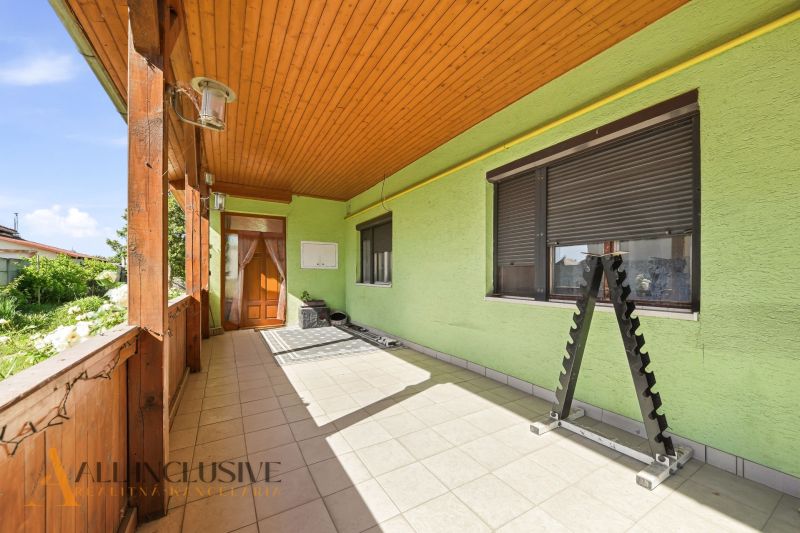 A family house in Hviezdoslavov with a decorated terrace and paving, light green plaster.