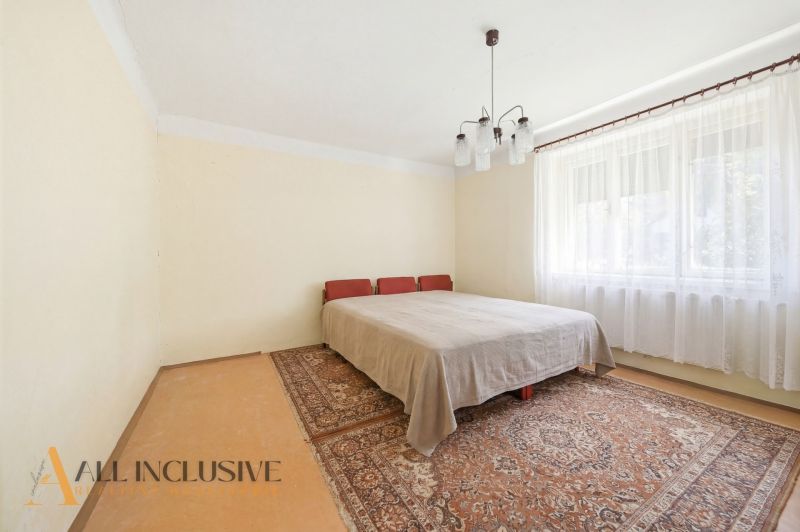 A bedroom in a family house with carpets and curtains.