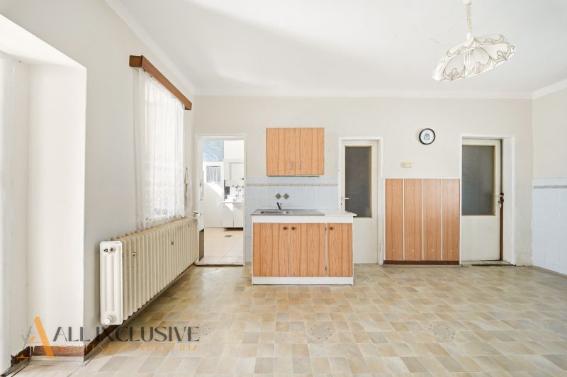 A kitchen in a family house with a wooden decor floor and wooden cabinets.