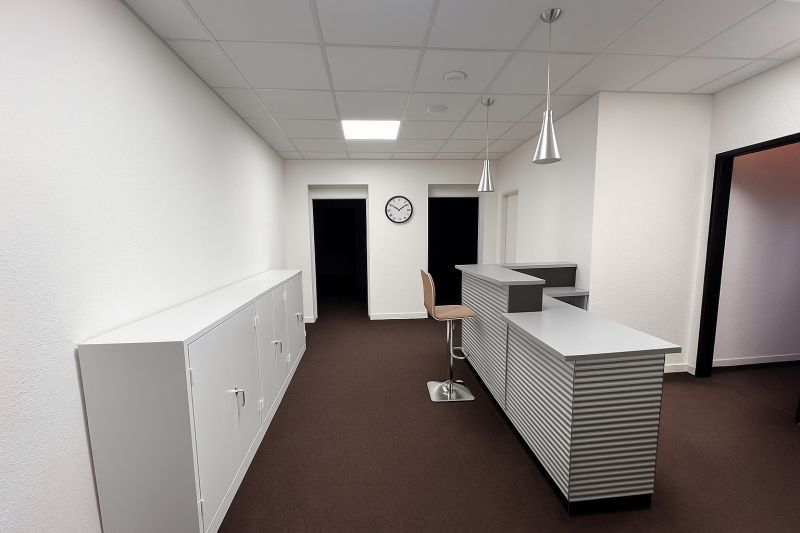Offices with a reception, white cabinets, and brown carpet, floor with wood decor.